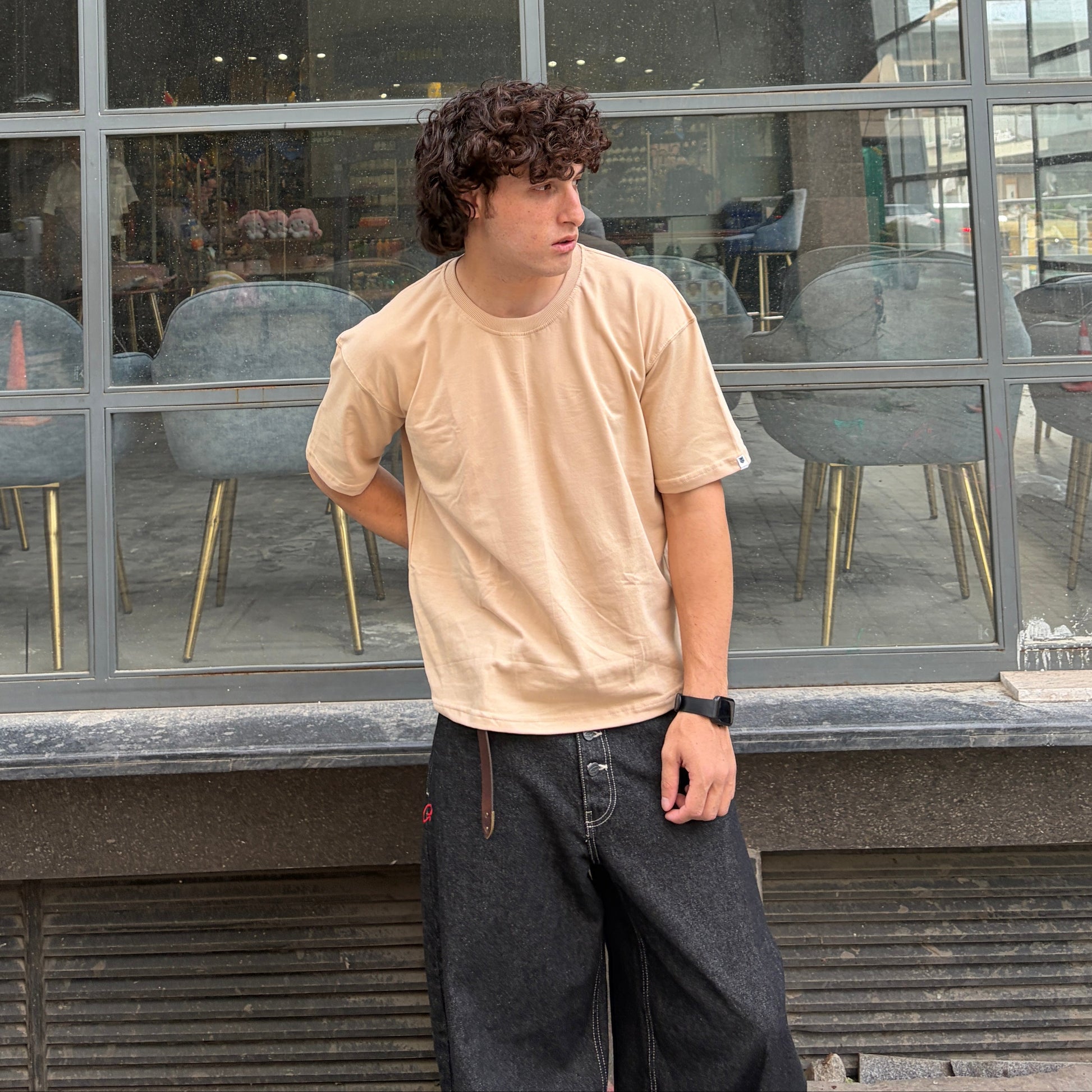 Person standing in front of a glass building with 'MARKET' sign.