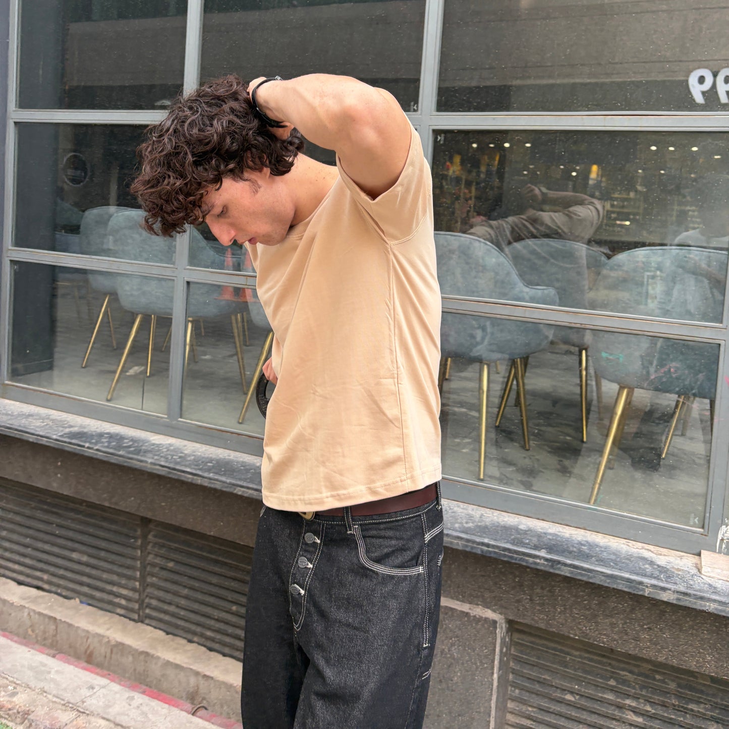 Man stretching outside a building with large glass windows