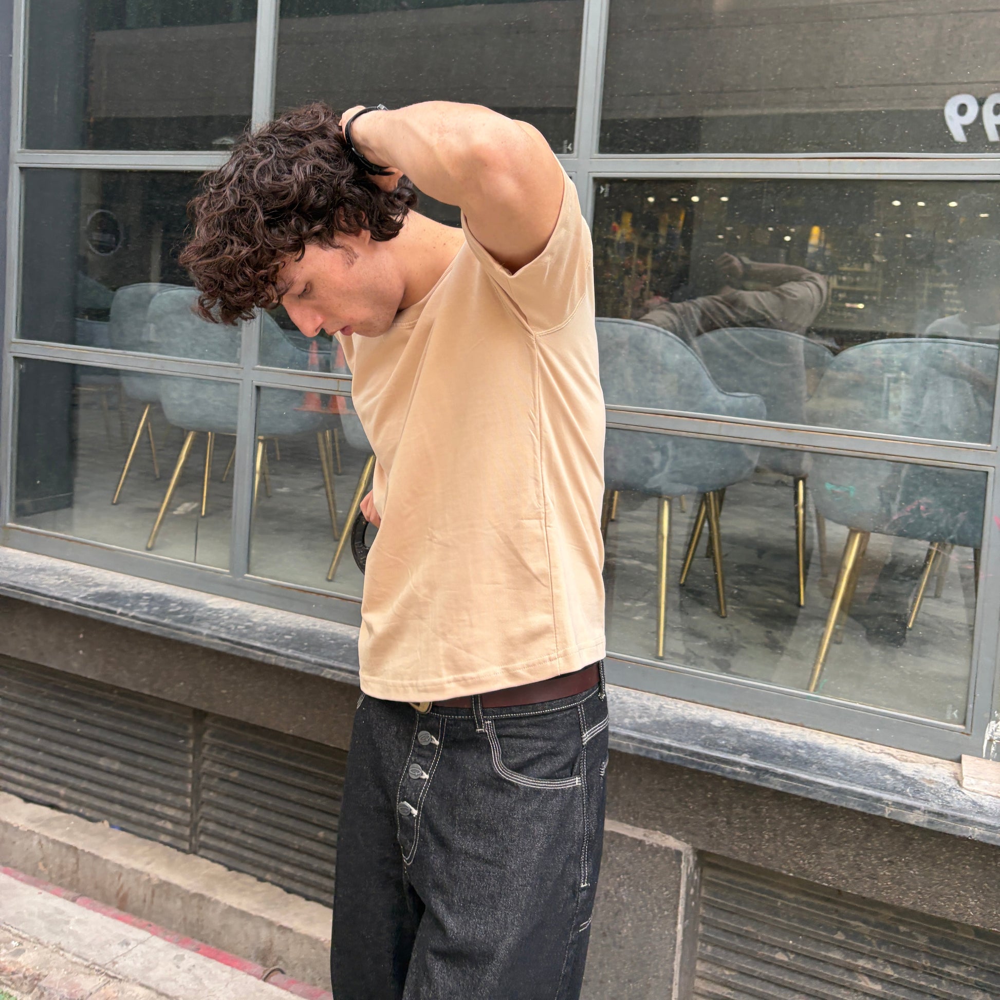 Man stretching outside a building with large glass windows